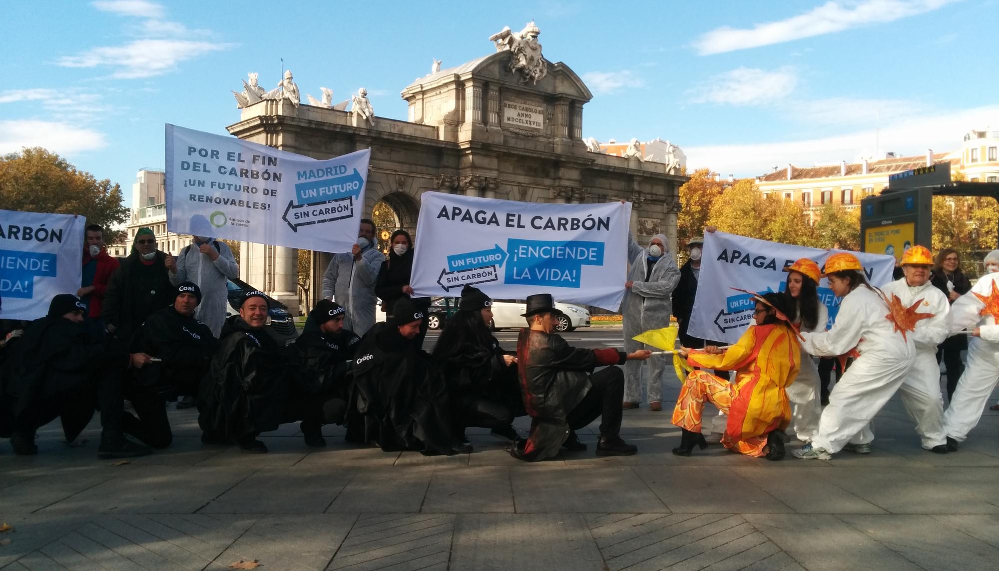 Activistas de la plataforma Un futuro sin carbón piden en Madrid, junto a la Puerta de Alcalá, el fin del carbón