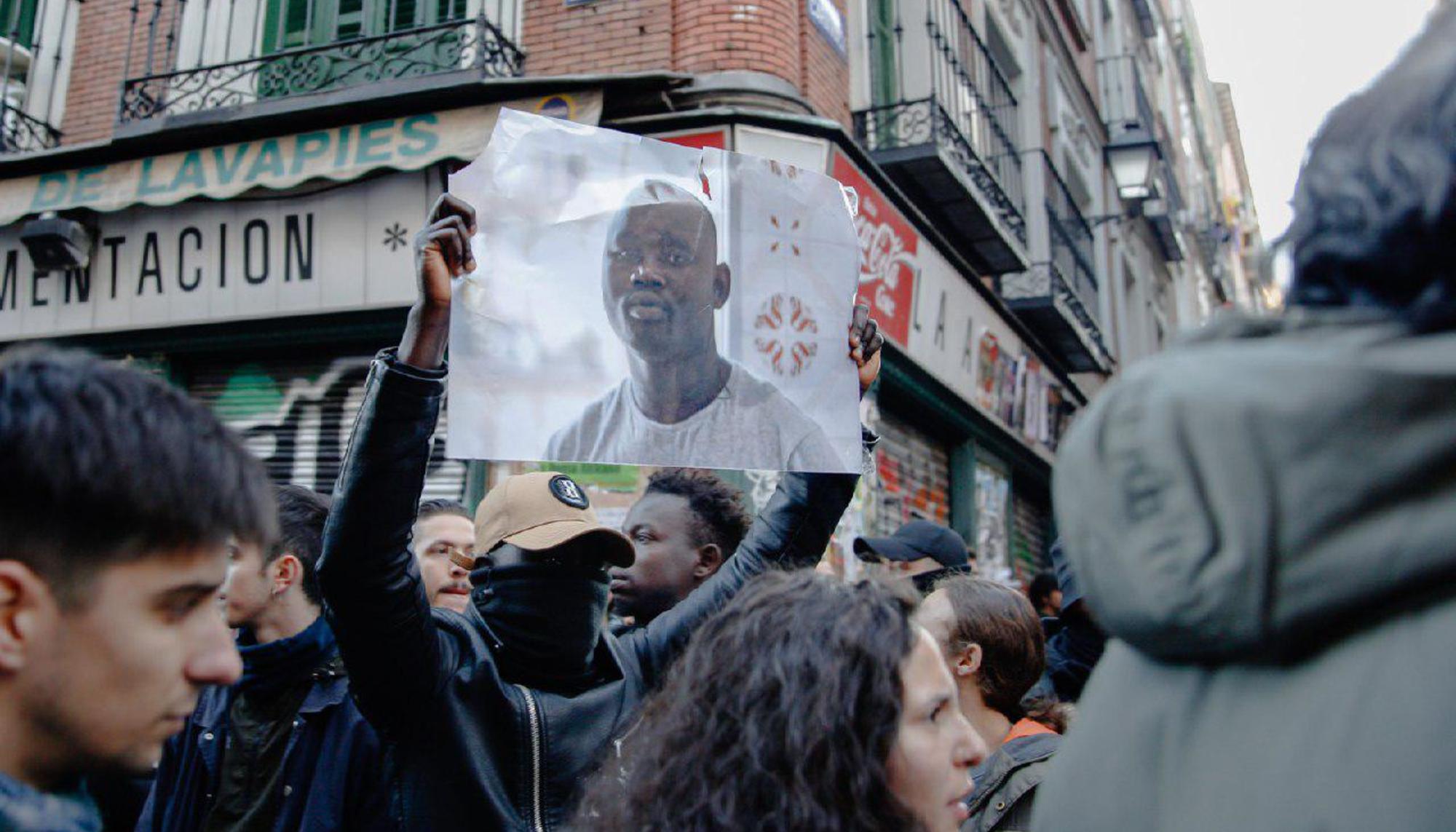 Un manifestante sostiene el retrato de Mame Mbaye en la manifestación del 16 de marzo de 2018. 