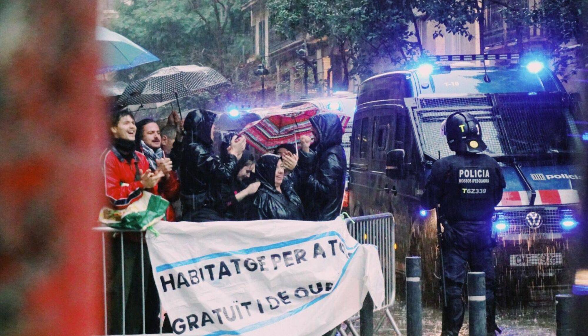 Manifestantes del movimiento de vivienda del Raval protestan por un desahucio de una familia con un menor a cargo en plena alerta roja por tormentas.