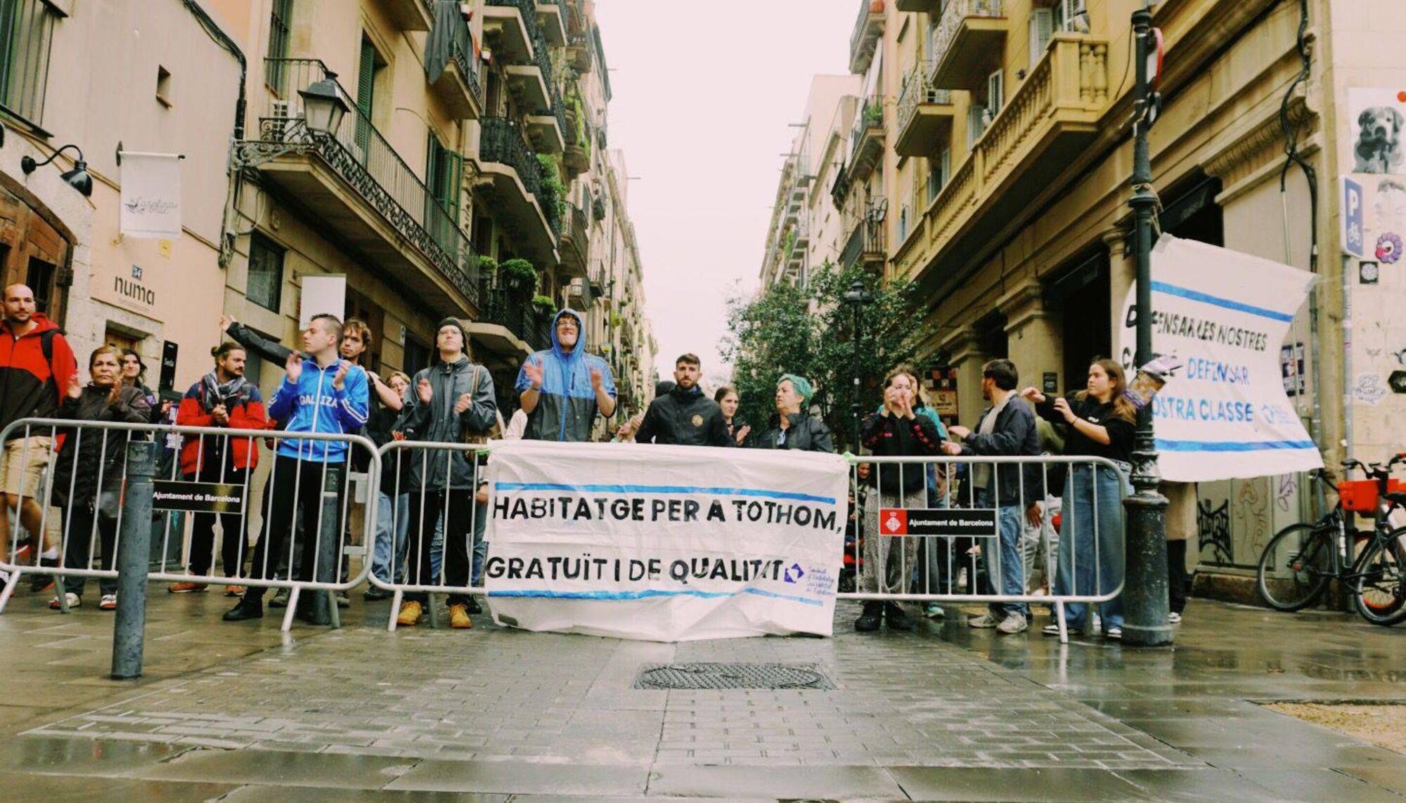 Militantes del Sindicato de Vivienda del Raval intentan parar un desahucio en plena alerta por tormenta en Barcelona.