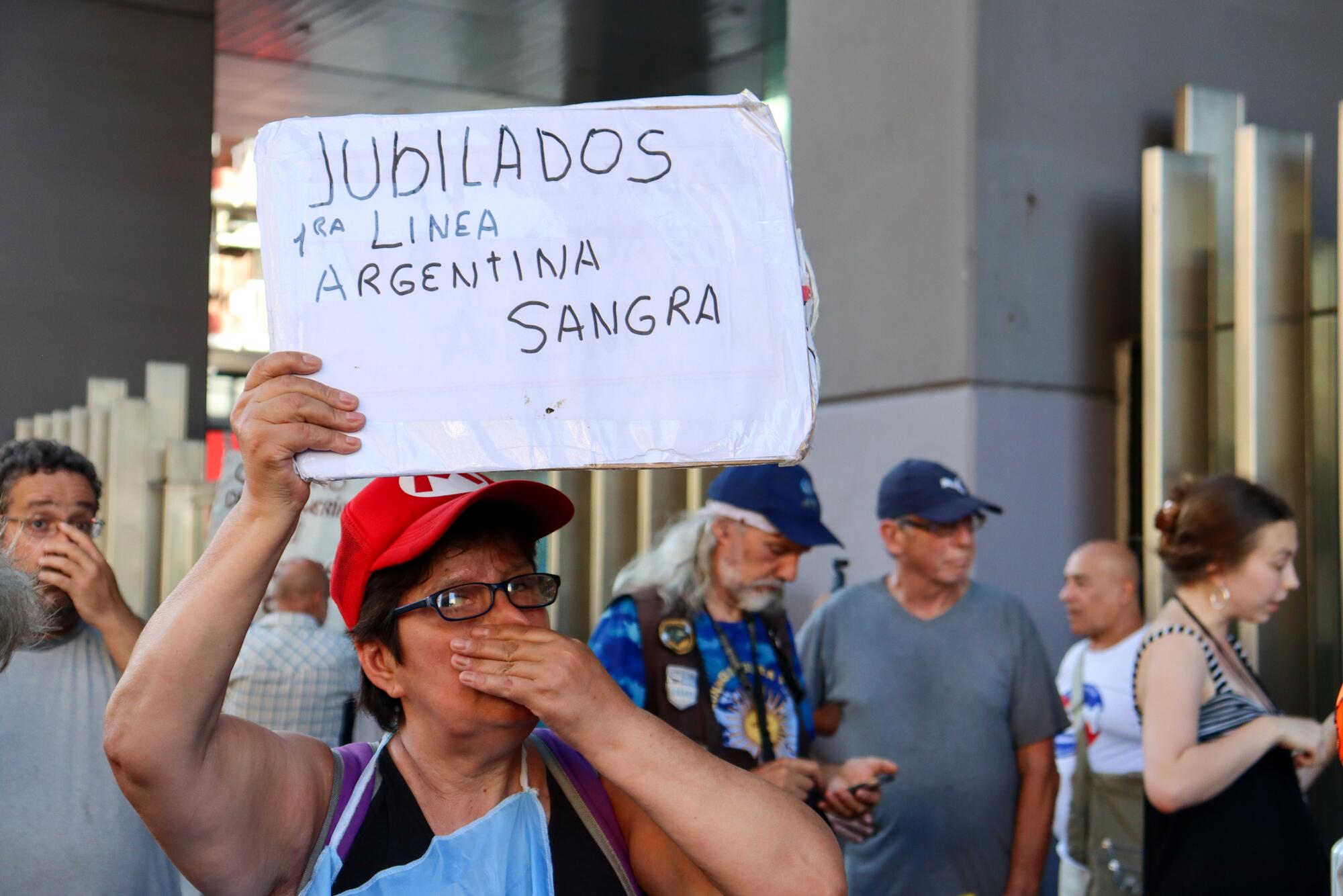 Pensionista afectada por los recortes de Milei protesta frene al Congreso en marzo de 2025.